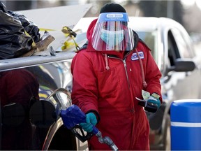 A gas station attendant wears various PPE items while working at the 8716 149 St. Domo location during the COVID-19 pandemic, in Edmonton Saturday April 18, 2020.