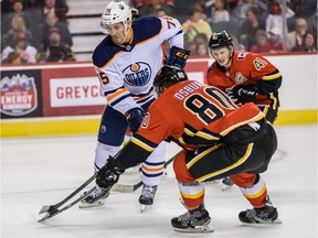 Edmonton Oilers Evan Bouchard and Calgary Flames Zach Osburn fight for the possession of the puck during the battle of Alberta prospects game at Scotiabank Saddledome in Calgary on Tuesday, September 10, 2019.