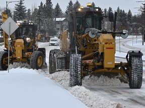 Three graders heading down 114 St. clearing the accumulation of snow, March 31, 2020. File photo
