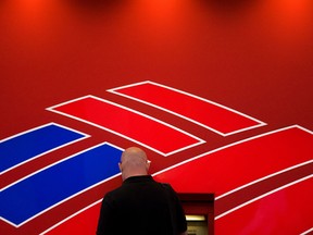 FILE PHOTO: A man uses a Bank of America ATM near the Bank of America corporate headquarters in Charlotte, North Carolina, September 18, 2008. REUTERS/Chris Keane/File Photo ORG XMIT: FW1