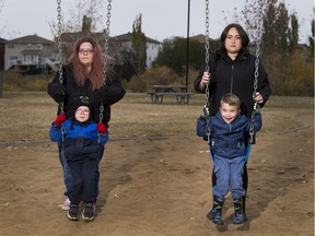 Two mothers with their sons on the swing