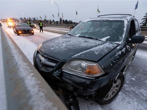 A crashed Acura SUV is seen on the 82 Avenue bridge west of 93 Street as snow falls in Edmonton, on Monday, Oct. 19, 2020.