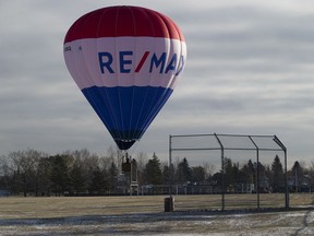 A hot air balloon prepares to land in a field near the Ottewel community centre on Tuesday, Oct. 20, 2020 in Edmonton.