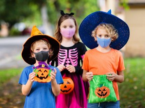Kids trick or treat in Halloween costumes and face masks in this stock file photo.