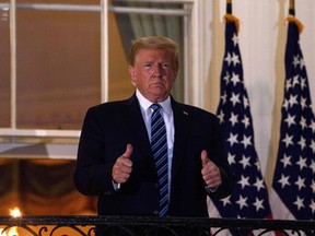 In this file photo taken on Oct. 05, 2020, US President Donald Trump gives two thumbs up from the Truman Balcony upon his return to the White House from Walter Reed Medical Center, where he underwent treatment for Covid-19, in Washington, DC. - President Donald Trump should be able to resume "public engagements" from October 10, 2020, the White House physician announced on October 8, saying the US leader has responded "extremely well" to Covid-19 treatment.