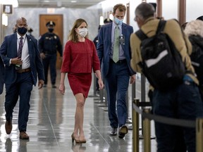 Amy Coney Barrett, U.S. President Donald Trump's nominee for associate justice of the U.S. Supreme Court, center left, wears a protective mask in a hallway during a break of a Senate Judiciary Committee confirmation hearing in Washington, D.C., U.S., on Tuesday, Oct. 13, 2020.