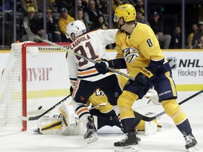Edmonton Oilers left wing Drake Caggiula (91) scores a goal as Nashville Predators' Kyle Turris (8) defends in the first period of an NHL hockey game Saturday, Oct. 27, 2018, in Nashville, Tenn.