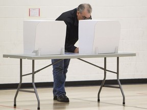 A man marks his ballot at A. Blair McPherson School in Edmonton, Alta. on Monday, Oct. 21, 2013. Amber Bracken/Edmonton Sun/QMI Agency