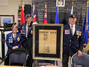 Former Stony Plain Legion Branch 256 president Pat Hale, left, Mel Lee and current president Darren Papish hold a framed edition of the Edmonton Journal from 1945. Lee donated the framed front page, which was purchased by his father following the end of the Second World War, to the legion in October.
