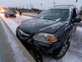 A crashed Acura SUV is seen on the 82 Avenue bridge west of 93 Street as snow falls in Edmonton, on Monday, Oct. 19, 2020. Multiple crashes occurred when snow made the bridge surface slick.