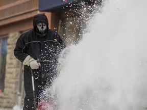 Kitt Willey kicks up a wall of snow while clearing sidewalks in downtown Saskatoon in January (Matt Smith / Saskatoon StarPhoenix)