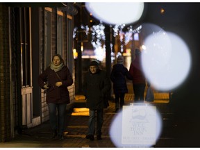 Pedestrians make their way down Whyte Avenue, Edmonton's popular nightlifes strip, in October. The province is requiring restaurants and bars to close at 11 p.m. for two weeks.