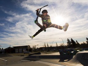 Dante Berlando,12, spends his lunch break from his online classes practicing his jumps on his scooter at the Fulton Ravine South Park on Wednesday, Nov. 4, 2020 in Edmonton.   His goal is to make a living riding his scooter.