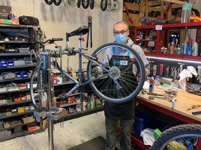 Sport Central's Jim Harvey earn's a pay cheque on his last day fixing bikes on Friday, Nov. 20, 2020. While he is officially retiring after a 20-year career, he loves fixing used bikes and plans to continue helping make bikes roadworthy for youngsters in needy families.