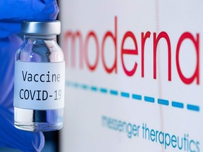 This file photo taken on Nov. 18, 2020 shows a bottle reading "Vaccine COVID-19" next to the Moderna biotech company logo.