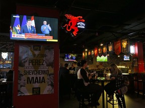 Patrons at Side Street Pub and Grill watch as Alberta Premier Jason Kenney places new restrictions to help fight the rise of COVID-19 in Calgary on Tuesday, Nov. 24, 2020