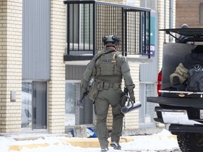 Members from the Edmonton Police Service Tactical Section work at the scene of an incident at an apartment building along 108 Street north of 107 Avenue, in Edmonton, Saturday Nov. 14, 2020.