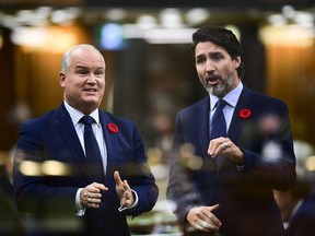 In the multiple-exposed image Conservative Leader Erin O'Toole, left, asks a question and Prime Minister Justin Trudeau answers during question period in the House of Commons on Parliament Hill in Ottawa on Wednesday, Nov. 4, 2020.