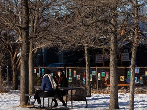 A couple of women take some time to take in the warm weather on a picnic bench at Garneau School at 109 Street in Edmonton, on Sunday, Dec. 6, 2020. Photo by Ian Kucerak