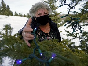 LuAnne Sirdiak, fundraiser chair for St. Albert Sturgeon Hospice Association, holds some of the remaining Christmas tree lights outside the Foyer Lacombe Hospice in St. Albert on Wednesday, Dec. 2, 2020. Thousands of lights were stolen off the trees outside of the hospice on Monday or early Tuesday.