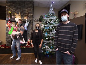 Edmontonians Chris Malhomme, left, holds his daughter Mia, 6, beside Shayesteh Majdina and Brandon Saint, right, who have started a holiday helper program called the Reindeer Exchange that matches donors to families in need.