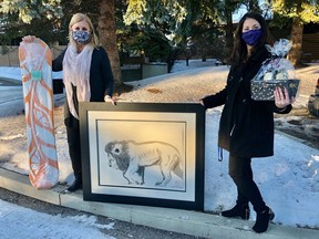 Showing some of the items CASA is auctioning online to help bridge the $1 million lost because of COVID-19 fundraising event cancellations are Nadine Samycia, CASA Foundation executive director and her assistant Ashley Pearce.