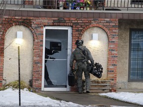 An Edmonton police tactical officer enters an apartment building with a robot to clear a suite that may have been connected to a fatal shooting on 109 Street and 109 ave on Tuesday, Dec. 8. 2020.