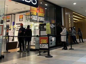 Shoppers line up at a store in Edmonton City Centre on Friday, Dec. 11, 2020.