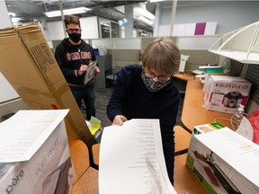 Volunteers Patricia Burr (right) and Mike Friel check off a list of fundraising items at the Christmas Bureau's offices in the Jerry Forbes Centre in Edmonton, on Thursday, Dec. 17, 2020. Photo by Ian Kucerak