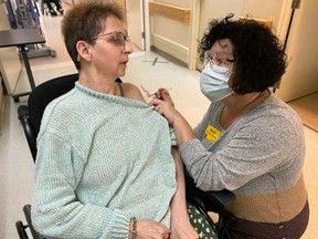 Sheila Veeder, 63, a resident of the Riverview Care Centre in Medicine Hat, is the first long-term care resident in Alberta to receive the Moderna COVID-19 vaccine on Wednesday, Dec. 30, 2020.