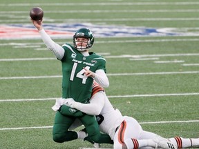 New York Jets quarterback Sam Darnold  manages to pass the football as Cleveland Browns defensive lineman Myles Garrett tackles him during NFL action on Dec. 27, 2020, at East Rutherford, N.J.