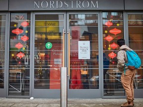 A man stands in front of a Nordstrom store in a locked-down downtown Toronto on Nov. 23, 2020. The entire province of Ontario will be going into lockdown on Dec. 26.