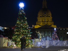 Visitors to the Alberta Legislature grounds take in the Christmas lights, in Edmonton Thursday Dec. 10, 2020.