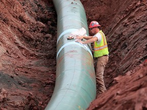 A pipe fitter lays the finishing touches to the replacement of Enbridge Energy's Line 3 crude oil pipeline stretch in Superior, Minn., in 2017.
