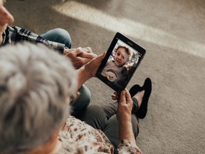 Garry and Vivien Hodge chat with their grandson, Roman Acres, on a device provided by Project Joy, an organization that hands out cellphones and tablets for seniors isolated due to COVID-19.