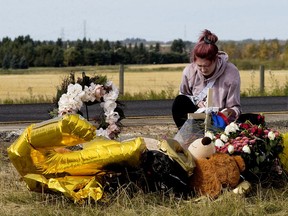 Natalie Birch, 17, tends a memorial for her friend Alex Ollington and Keithan Peters along Highway 21 north of Township Road 542, near Fort Saskatchewan Monday, Sept. 21, 2020.