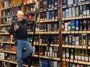 Steve Richmond, founder of Edmonton's Whisky Festival, takes a  bottle of single malt scotch from a shelf at his Vines Liquor Store.
