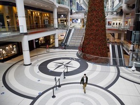 A shopper wearing a protective mask walks through a nearly empty Eaton Centre mall in Toronto, in November.