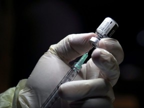 A health-care worker prepares to administer a Pfizer/BioNTEch coronavirus disease (Covid-19) vaccine at The Michener Institute, in Toronto on Dec. 14, 2020.