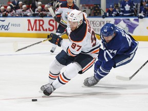 Connor McDavid (97) of the Edmonton Oilers swings around Morgan Rielly (44 )of the Toronto Maple Leafs at Scotiabank Arena on Jan. 22, 2021. The Maple Leafs defeated the Oilers 4-2.