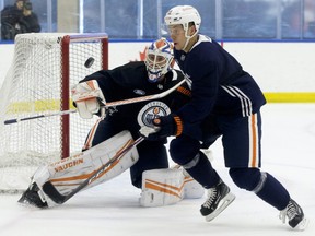 Goaltender Mikko Koskinen and Dominik Kahun (21) track a loose puck during an Edmonton Oilers training camp scrimmage, in Edmonton Thursday Jan. 7, 2021.