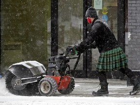 A man wearing a kilt clears snow off the sidewalk on 107 Avenue near 116 Street in Edmonton on Wednesday January 27, 2021. Temperature in the city was -15C degrees.