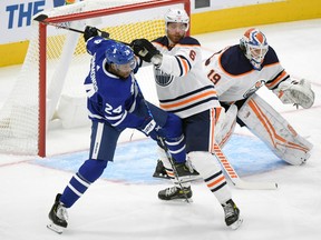 Oilers defenseman Adam Larsson (6) battles for position with Toronto Maple Leafs forward Wayne Simmonds (24) in front of goalie Mikko Koskinen (19) in the first period at Scotiabank Arena on Jan. 20, 2021.