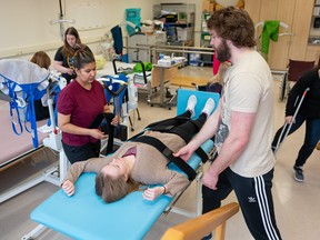 Students practice different techniques for working with patients challenged by mobility issues in this mobility lab lesson. (Photo taken before COVID-19)