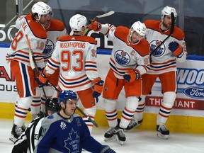 Edmonton Oilers Connor McDavid (97) is congratulated by teammates after scoring on a power play against the Toronto Maple Leafs at Rogers Place in Edmonton on Saturday, Jan. 30, 2021.
