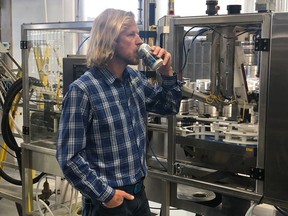 Michael Wood, president of rök Glacier Water, samples a can of his product.