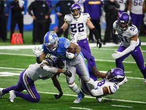 Detroit Lions wide receiver Marvin Jones (11) is tackled by Minnesota Vikings free safety Anthony Harris (41) and cornerback Dylan Mabin (39) during the fourth quarter at Ford Field on Sunday.