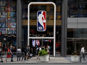 The NBA logo is displayed as people pass by the NBA Store in New York City on Oct. 7, 2019.