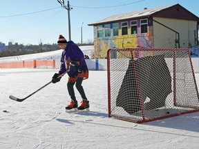 A boy plays hockey at the Riverdale Community League outdoor skating rink on Jan. 7, 2021. Community leagues are concerned they will bear the brunt of COVID-19 fines if their unsupervised community rinks are attracting large groups.