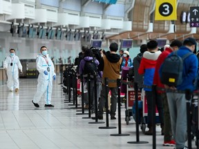 People line up and check in for an international flight at Pearson International airport during the COVID-19 pandemic in Toronto on Wednesday, Oct. 14, 2020.